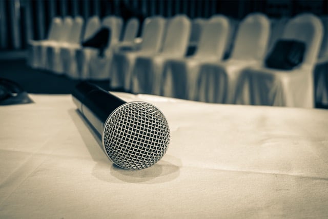Crowd gathered around DJ equipment at an indoor event